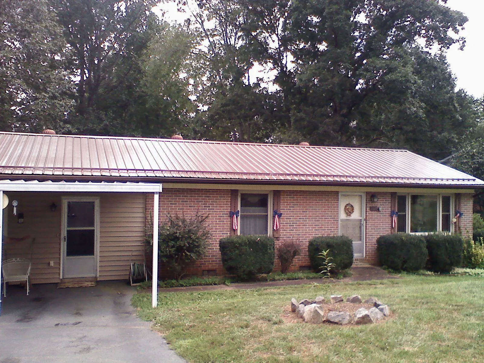 Bronze metal roof and carport on a brick ranch home — Roof Repair work by our crew in Woodruff