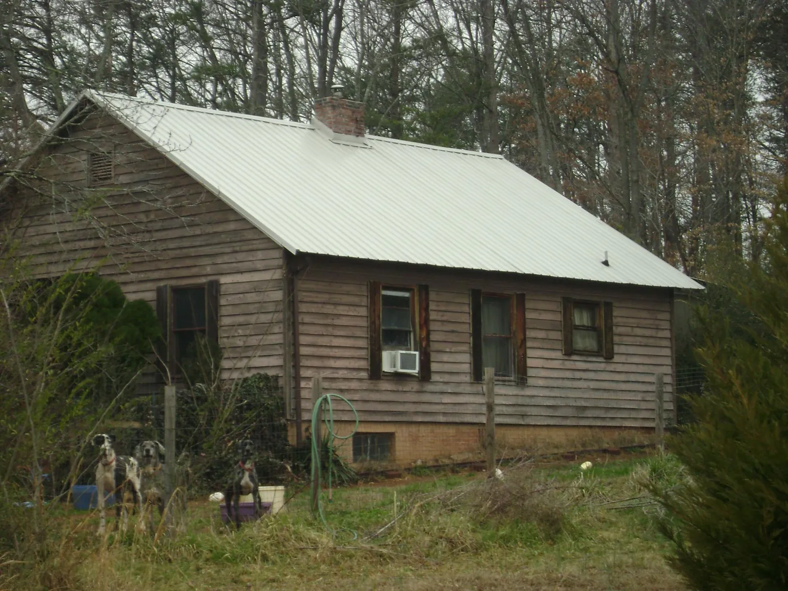 White metal roof on an old wood sided farmhouse, from a Metal Roof Installation job in Woodruff